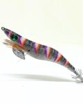Señuelo jibionera para pesca de cefalópodos, diseño realista con cuerpo segmentado, ojos prominentes y corona de anzuelos múltiples. Ideal para atraer sepias y calamares en aguas costeras. Modelo con patrón negro, naranja y lila, plumas laterales y aleta metálica para mayor estabilidad.