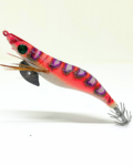 Señuelo jibionera para pesca de cefalópodos, diseño realista con cuerpo segmentado, ojos prominentes y corona de anzuelos múltiples. Ideal para atraer sepias y calamares en aguas costeras. Modelo color rosa con patrón negro y lila fluor, plumas laterales y aleta metálica para mayor estabilidad.