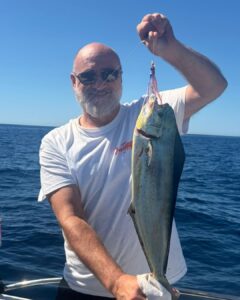 sergio burillo pesca de llampuga, sujeta una gran llampuga pescada con un señuelo de cabeza de cristal